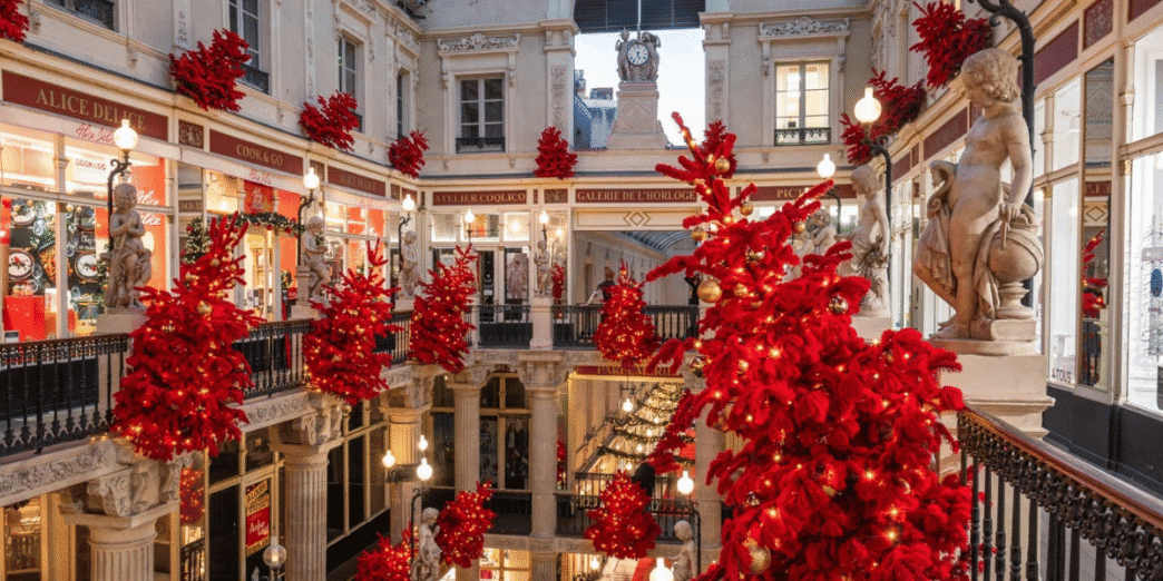 Vitrines décorées de Noël dans le centre historique de Nantes avec statues et décorations rouges lumineuses.