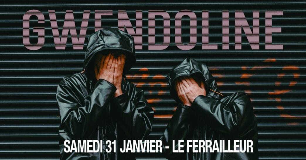 Homme en blouson noir avec capuche, couvre son visage devant une façade sombre.