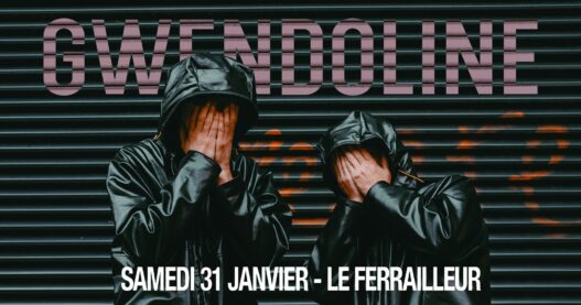 Homme en blouson noir avec capuche, couvre son visage devant une façade sombre.