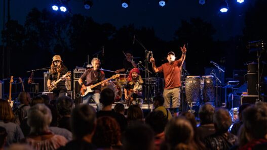 Concert live en plein air, groupe de musiciens jouant sous un éclairage nocturne vibrant à Nantes.
