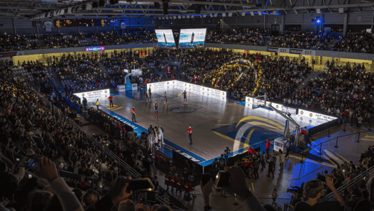 Lumière sur un match de basketball vibrant au Big City Nantes, avec public enthousiaste et ambiance énergique.