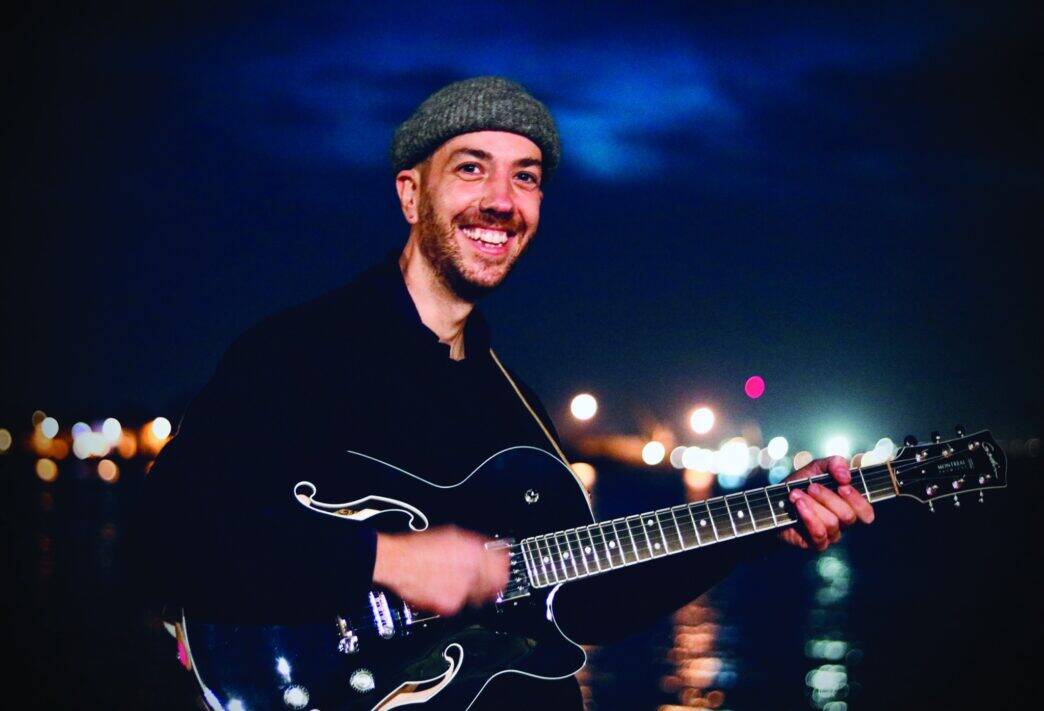 Musicien jouant de la guitare à Nantes, ambiance nocturne, vie culturelle dynamique.