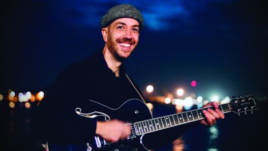 Musicien jouant de la guitare à Nantes, ambiance nocturne, vie culturelle dynamique.