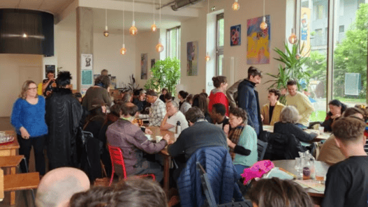 Café animé à Nantes avec clients dans un intérieur moderne et lumineux.