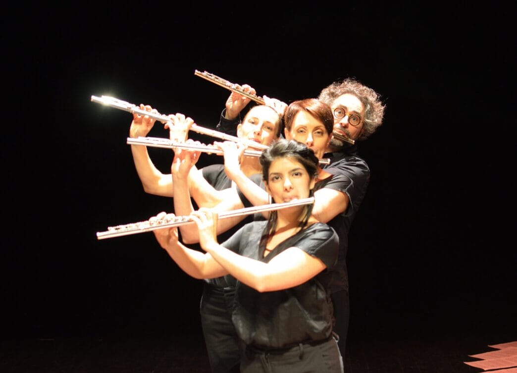 Groupe de musiciens jouant de la flûte avec passion sur scène.
