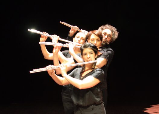 Groupe de musiciens jouant de la flûte avec passion sur scène.