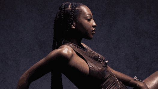 Jeune femme noire en tenue sportive, posant avec confiance.