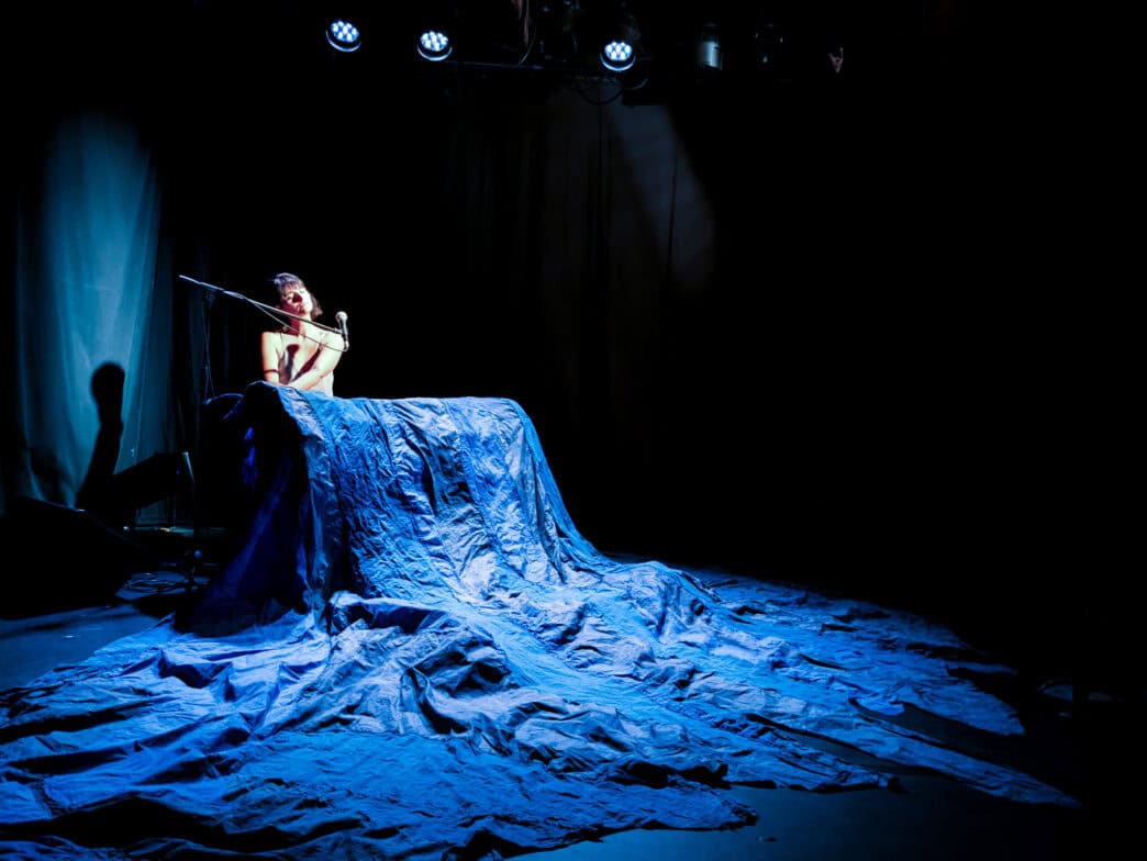 Performance artistique représentant la liberté et l'expression corporelle, avec une figure nue sur s.
