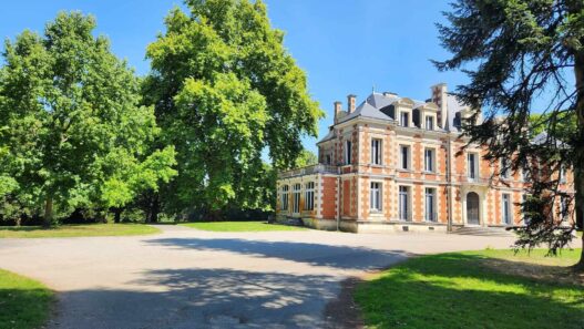 Château ancien entouré de verdure et d'arbres majestueux, situé dans un parc paisible à Nantes.
