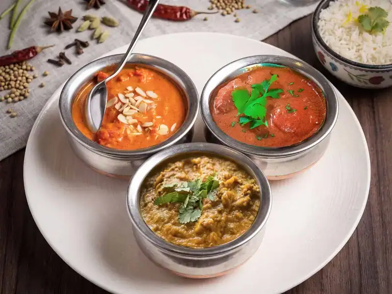 Trois curries indiens servis avec du riz chez Curry House